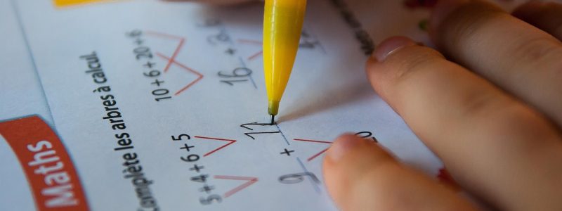 五十音学习工具对比展示——桌面上摆放着练习册、手机App界面和教材，呈现多种学习工具的搭配使用场景